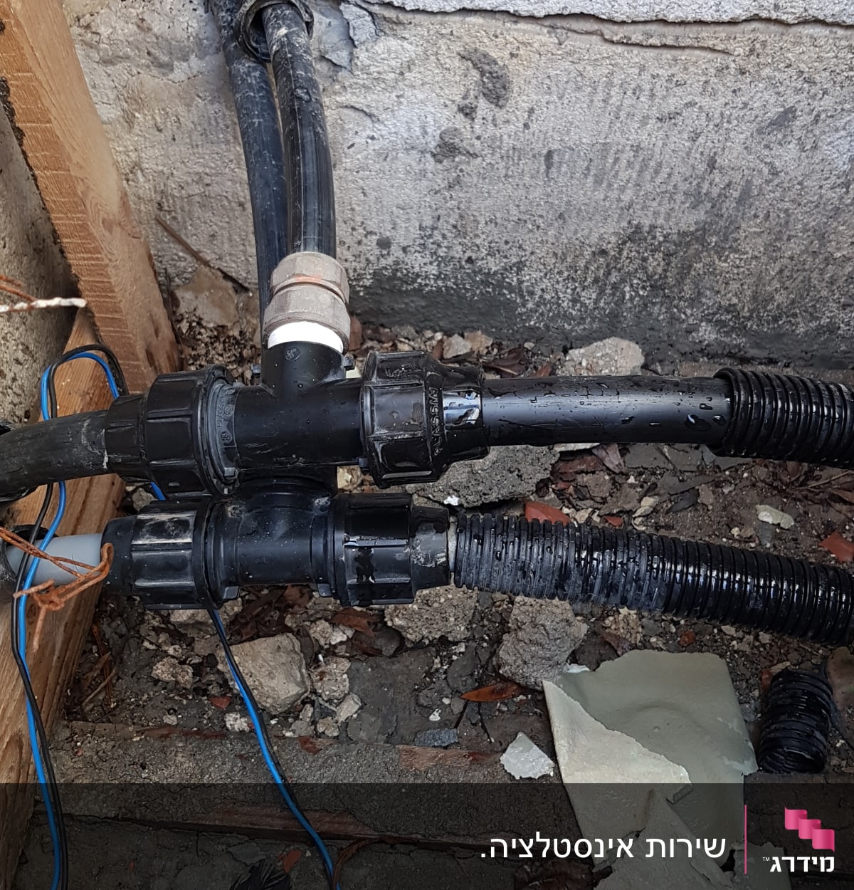 צינורות פלסטיק מחוברים עם מחברים, על רקע קיר בטון.